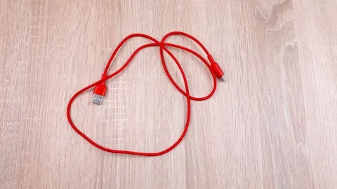 USB cable. The red USB cable is on the table. Stock Footage 299727895