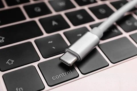 USB cable with type C connector on laptop keyboard, closeup Fotos Stock