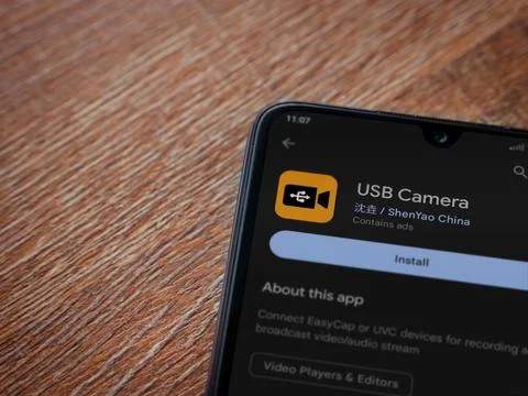 USB Camera app play store page on smartphone on wooden background Stock Photos