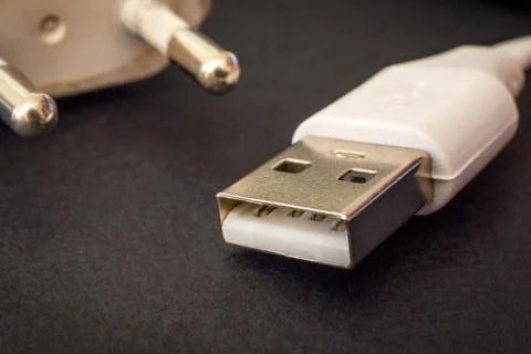 USB charger cable on black surface closeup often used for charging a smartpho Stock Photos