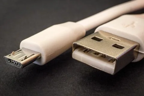 USB charger cable on black surface closeup often used for charging smartphone Stock Photos