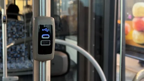 USB charger for mobile device in interior of regular city bus Stock Footage 304562801