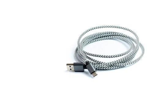 USB data cable with fabric braid rolled up on white, isolated close-up, space Stock Photos