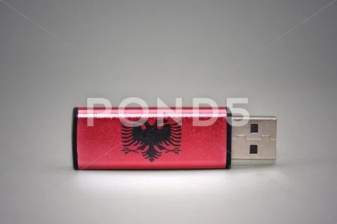 Usb flash drive with the national flag of albania on gray background. Stock Photos