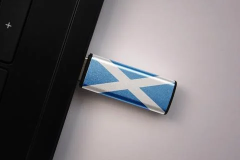 Usb flash drive in notebook computer with the national flag of scotland on .. Stock Photos
