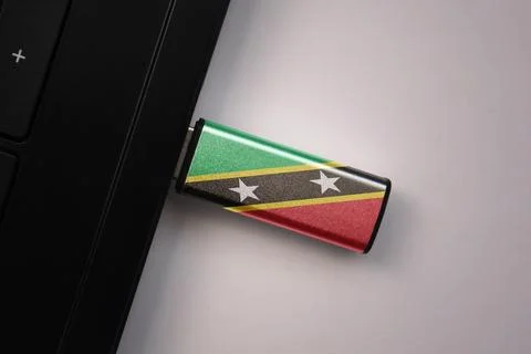 Usb flash drive in notebook computer with the national flag of saint kitts .. Stock Photos