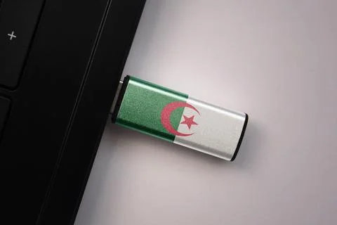 Usb flash drive in notebook computer with the national flag of algeria on gra Stock Photos