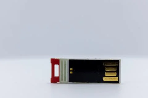 A USB flash drive with a red connector on a white background. Stock Photos