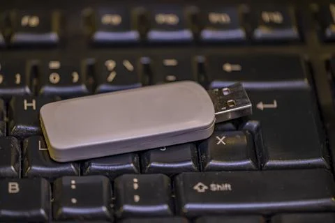 A USB flash drive is sitting on a keyboard Stock-Fotos