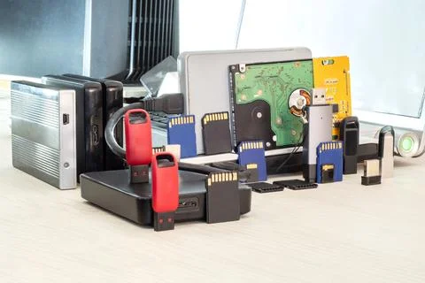 USB flash drives, memory cards, and external hard drives against a laptop Stock Photos