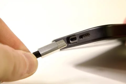 USB Type C cable and smartphone in hand Fotos de archivo