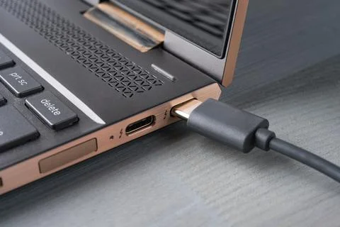 USB Type C grey cable being connected to the laptop. Stock Photos