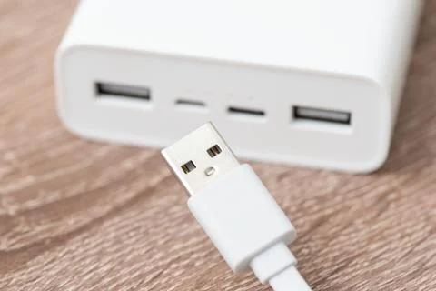 USB type A cable in front of big white powerbank Stock Photos