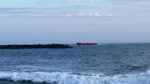 USCG U.S. Coast Guard Red Ship Coming In to Port Hueneme Harbor Behind Jetty HD Stock Footage 249984695