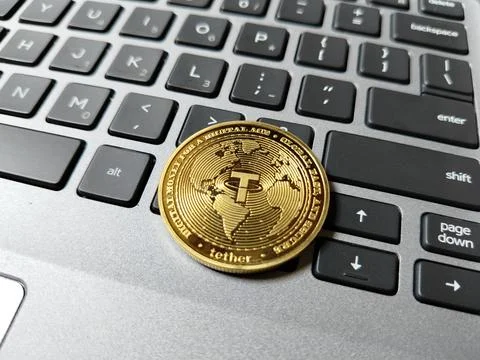 A USDT (Tether) token resting on a computer keyboard, illustrating stablecoin ad Stock-Fotos