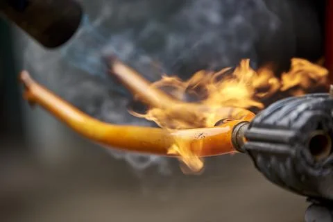 Use of a blowtorch to remove the paint of an orange bicycle fork Stock Photos