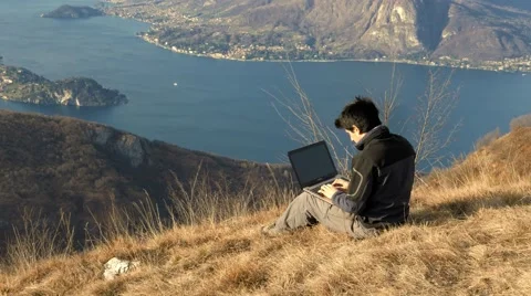Use the computer to work in front of a beautiful landscape Stock Footage 59714339