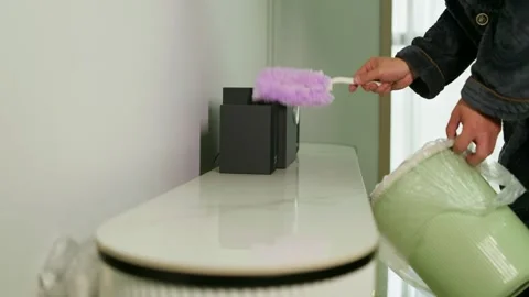 Use a duster to wipe the dust off the tabletop. Stock Footage 330835615