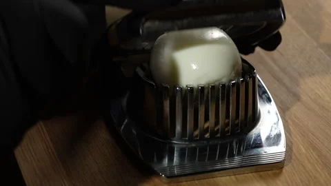Use an egg slicer to cut a boiled chicken egg. Cutting eggs into slices Stock Footage 302506376