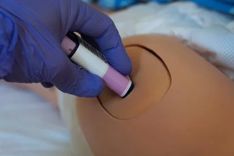 The use of an epinephrine auto-injector training device on a medical manneq.. Stock Photos