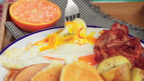 Use fork eat fried egg and bacon breakfast platter Vídeos de archivo 158435395