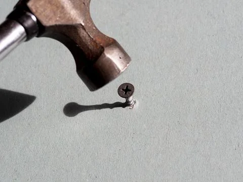 Use a hammer to hammer the screw. Error in selecting the tool. Stock Photos