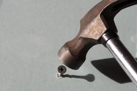 Use a hammer to hammer the screw. Error in selecting the tool. Stock Photos