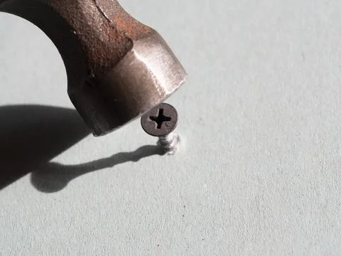 Use a hammer to hammer the screw. Error in selecting the tool. Stock Photos