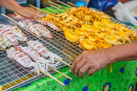 Use a hand of grilled squid on wire mesh. Stock Photos