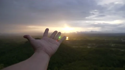 Use hand to touch the light of sunrise Video stock 166819660