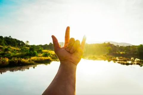 Use hand to touch the sun light in the morning, Love sign, Yellow light with  Stock Photos