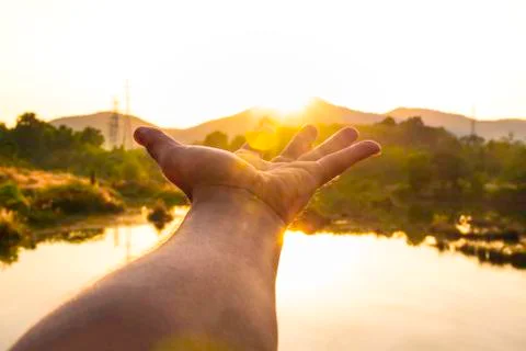 Use hand to touch the sun light in the morning, Pick up the sun, Close the su Stock Photos
