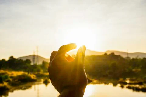 Use hand to touch the sun light in the morning, Pick up the sun, Close the su Stock Photos