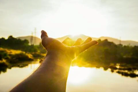 Use hand to touch the sun light in the morning, Pick up the sun, Close the su Stock Photos