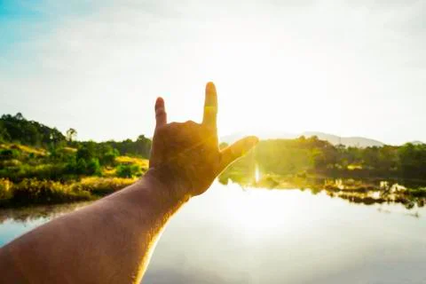 Use hand to touch the sun light in the morning, Love sign, Yellow light with  Stock Photos