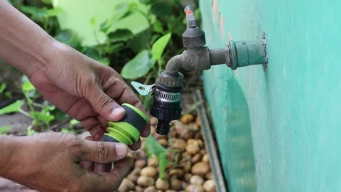 Use hands holding quick water faucet connector is connecting Stock Footage 148038906
