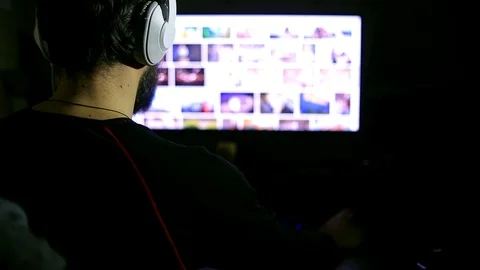 The use of the Internet, a bearded man sits in the night in front of the monitor Stock Footage 98899131