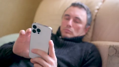 The use of the iPhone 13 Pro Max phone by ordinary people a man in a dark jacket Stock Footage 236522856