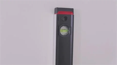 Use a level or plumb bob to draw a straight vertical line on the wall surface 库存影片 332245670
