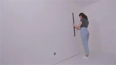 Use a level or plumb bob to draw a straight vertical line on the wall surface 動画素材 332369021