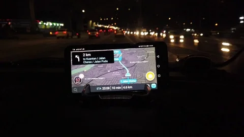 Use of navigation apps using smartphones at the top of the car dashboard at nigh Stock Footage 106071005