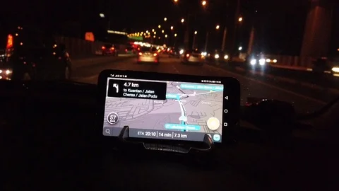 Use of navigation apps using smartphones at the top of the car dashboard at nigh Stock Footage 106072543