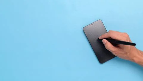 Use a pen to write on your smartphone. Stock Photos