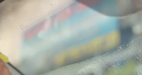 Use a sharp plastic to swipe on the glass to remove any glue residue on glass. Stock Footage 289557784