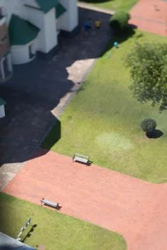 Use of slope-shear, tilt-shift, track, bench, church. grass Stock Photos