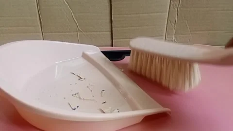 Use a small tool to sweep up the trash Stock Footage 316564301