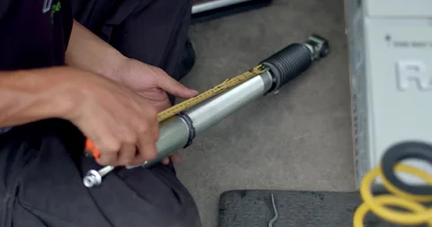 Use a tape measure to set the height of the shock absorber. Stock Footage 310015092