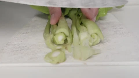 Use a vegetable knife on a plastic cutting board to prepare healthy or vegeta Stock-Footage 168519386