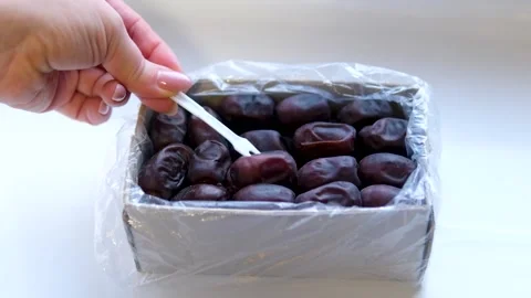 Use a white plastic fork to remove dates from the box Stock Footage 302073478