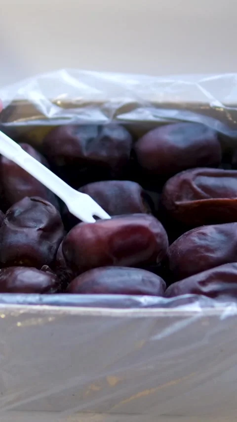 Use a white plastic fork to remove dates from the box Stock Footage 302732123